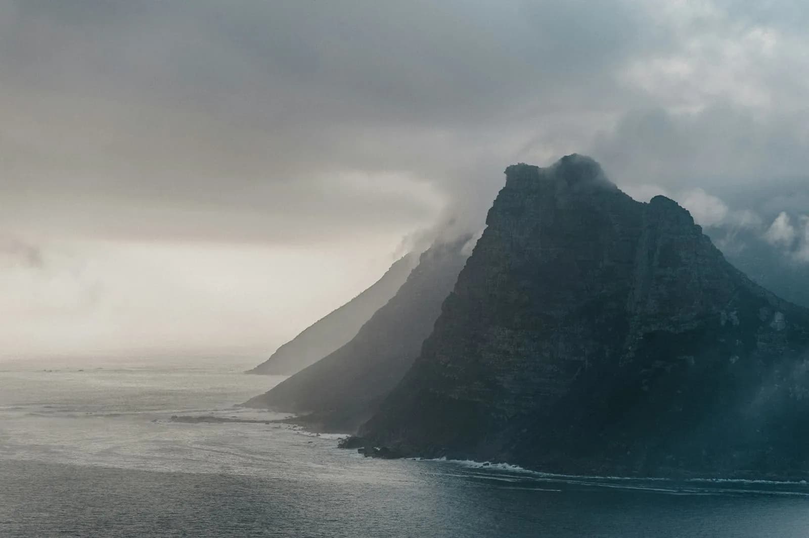 Mist over a coastal headland where cliffs meet the sea